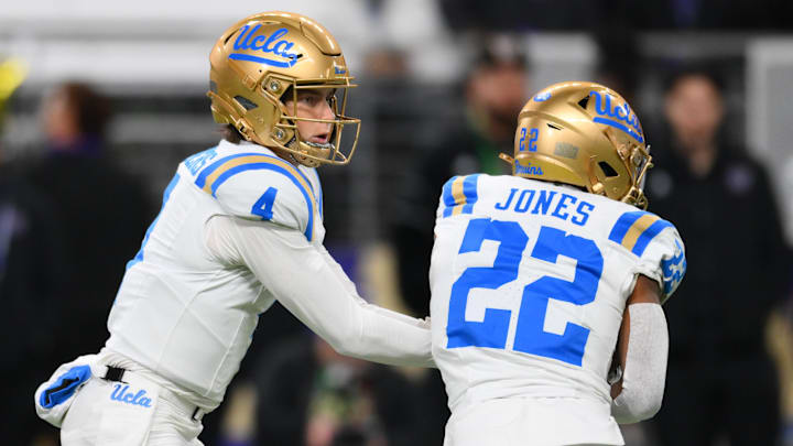 Nov 15, 2024; Seattle, Washington, USA; UCLA Bruins quarterback Ethan Garbers (4) hands the ball off to running back Keegan Jones (22) during the first half against the Washington Huskies at Alaska Airlines Field at Husky Stadium. Mandatory Credit: Steven Bisig-Imagn Images