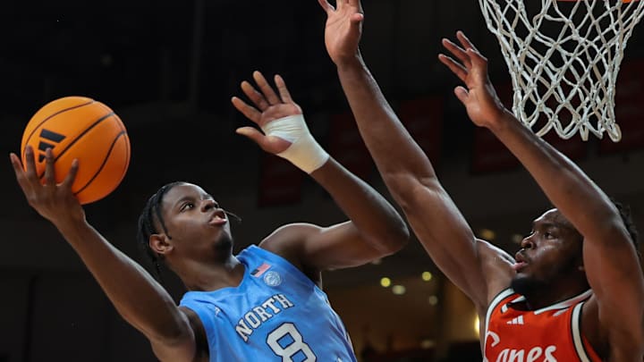 Feb 10, 2026; Coral Gables, Florida, USA; North Carolina Tar Heels forward Caleb Wilson (8) drives to the basket against Miami Hurricanes center Ernest Udeh Jr. (8) during the second half at Watsco Center. Mandatory Credit: Sam Navarro-Imagn Images