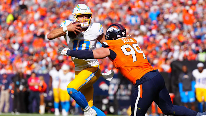 Oct 13, 2024; Denver, Colorado, USA; Denver Broncos defensive end Zach Allen (99) reaches for Los Angeles Chargers quarterback Justin Herbert (10) in the second quarter at Empower Field at Mile High. 