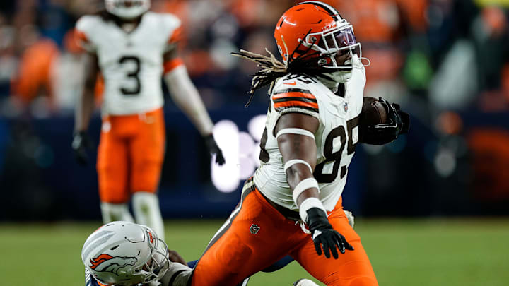 Dec 2, 2024; Denver, Colorado, USA; Cleveland Browns tight end David Njoku (85) is pulled down by Denver Broncos cornerback Ja'Quan McMillian (29) in the fourth quarter at Empower Field at Mile High. 