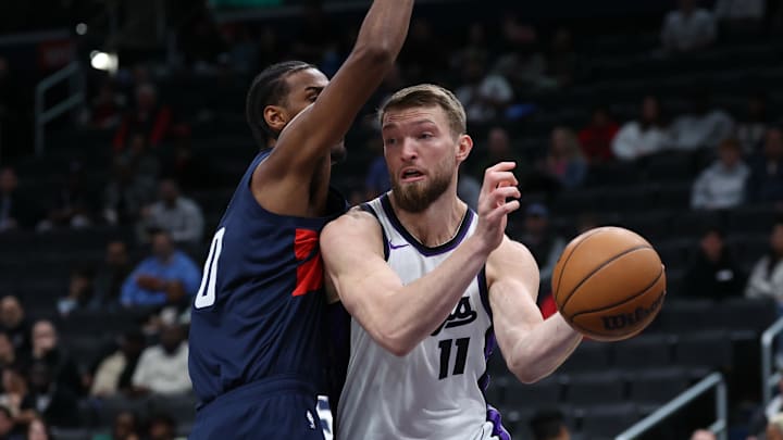 Apr 2, 2025; Washington, District of Columbia, USA; Sacramento Kings forward Domantas Sabonis (11) passes the ball as Washington Wizards forward Alex Sarr (20) defends in the first half at Capital One Arena.