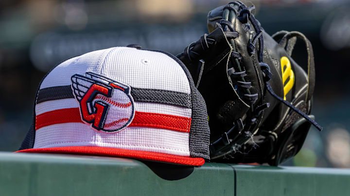 Jul 8, 2024; Detroit, Michigan, USA; A Cleveland Guardians baseball cap and glove sit on the dugout rail before the game against the Detroit Tigers at Comerica Park. Mandatory Credit: David Reginek-Imagn Images