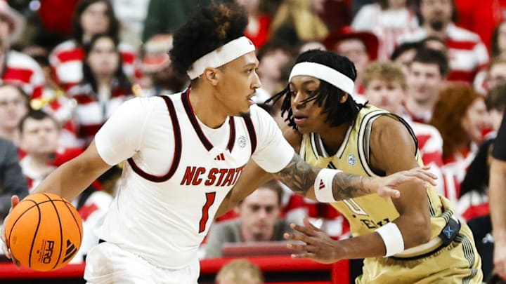 Jan 17, 2026; Raleigh, North Carolina, USA;  NC State Wolfpack forward Darrion Williams (1) dribbles with the ball guarded by Georgia Tech Yellow Jackets guard Akai Fleming (0) during the first half of the game at Lenovo Center. Mandatory Credit: Jaylynn Nash-Imagn Images