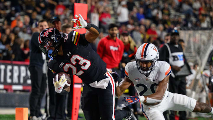 Maryland Terrapins running back Colby McDonald (23) is tackled by Virginia Cavaliers safety Jonas Sanker (20) 