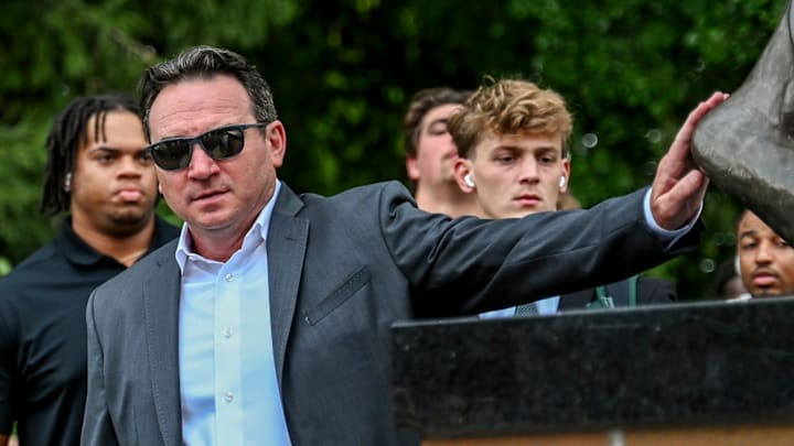 Michigan State's head coach Jonathan Smith touches the foot of the Sparty statue before the game against Florida Atlantic on Friday, Aug. 30, 2024, outside Spartan Stadium in East Lansing.