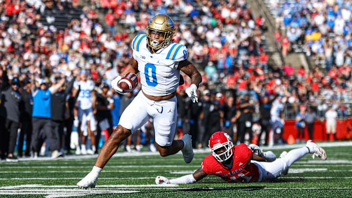 Oct 19, 2024; Piscataway, New Jersey, USA;  UCLA Bruins running back Jalen Berger (0) catches a pass for a touchdown as Rutgers Scarlet Knights linebacker Abram Wright (11) pursues during the second half at SHI Stadium. 