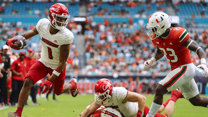 Nov 18, 2023; Miami Gardens, Florida, USA; Louisville Cardinals wide receiver Jamari Thrash (1) runs with the football for a touchdown against Miami Hurricanes linebacker K.J. Cloyd (23) during the fourth quarter at Hard Rock Stadium. Mandatory Credit: Sam Navarro-Imagn Images