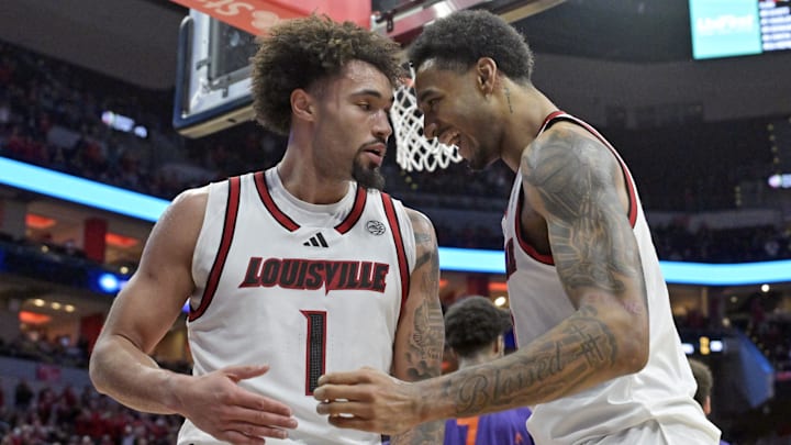 Jan 7, 2025; Louisville, Kentucky, USA; Louisville Cardinals forward James Scott (0) celebrates with guard J'Vonne Hadley (1) during the second half against the Clemson Tigers at KFC Yum! Center. Louisville defeated Clemson 74-64. 