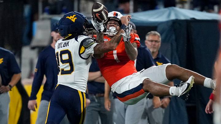 Sep 19, 2026; Charlotte, North Carolina, USA; Virginia Cavaliers receiver Rico Flores (1) is upended by West Virginia Mountaineers cornerback Nick Taylor (19) during the second half at Bank of America Stadium. Mandatory Credit: Jim Dedmon-Imagn Images Sep 19, 2026; Charlotte, North Carolina, USA; Virginia Cavaliers receiver Rico Flores (1) is upended by West Virginia Mountaineers cornerback Nick Taylor (19) during the second half at Bank of America Stadium. Mandatory Credit: Jim Dedmon-Imagn Images