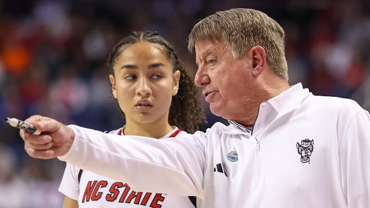 Mar 9, 2025; Greensboro, NC, USA;  NC State Wolfpack head coach Wes Moore talks with NC State Wolfpack guard Devyn Quigley (0) during the fourth quarter against Duke Blue Devils at First Horizon Coliseum. Mandatory Credit: Cory Knowlton-Imagn Images