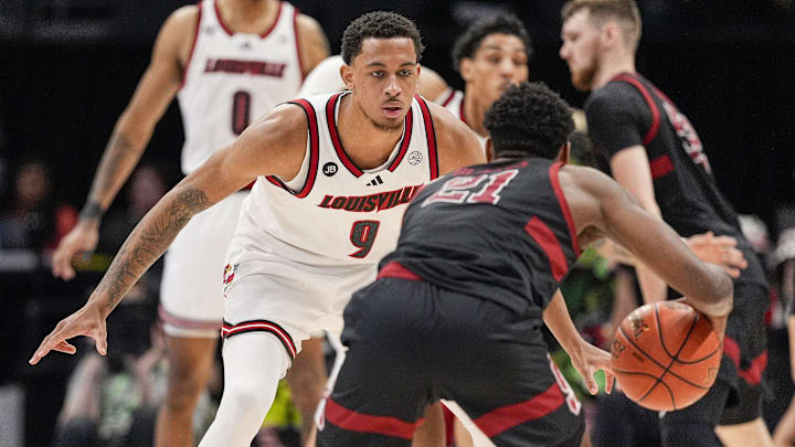 Mar 13, 2025; Charlotte, NC, USA; Louisville Cardinals guard Cole Sherman (4) on defense against Stanford Cardinal guard Jaylen Blakes (21) during the second half at Spectrum Center. Mandatory Credit: Jim Dedmon-Imagn Images