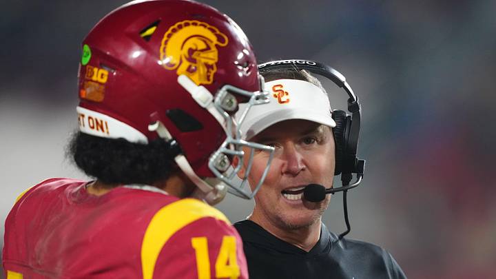 Nov 29, 2025; Los Angeles, California, USA; Southern California Trojans head coach Lincoln Riley (right) talks with quarterback Jayden Maiava (14) in the second half against the UCLA Bruins at United Airlines Field at Los Angeles Memorial Coliseum. Mandatory Credit: Kirby Lee-Imagn Images