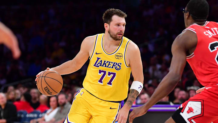 Mar 12, 2026; Los Angeles, California, USA; Los Angeles Lakers guard Luka Doncic (77) moves the ball against Chicago Bulls forward Jalen Smith (25) and forward Matas Buzelis (14)during the first half at Crypto.com Arena. Mandatory Credit: Gary A. Vasquez-Imagn Images