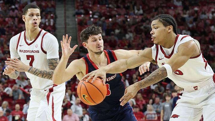 Arkansas Razorbacks guard Darius Acuff Jr (5) passes to forward Trevon Brazile (7) as Samford Bulldogs guard Keaton Norris (3) defends during the second half at Bud Walton Arena. Arkansas won 79-75. Arkansas Razorbacks guard Darius Acuff Jr (5) passes to forward Trevon Brazile (7) as Samford Bulldogs guard Keaton Norris (3) defends during the second half at Bud Walton Arena. Arkansas won 79-75.