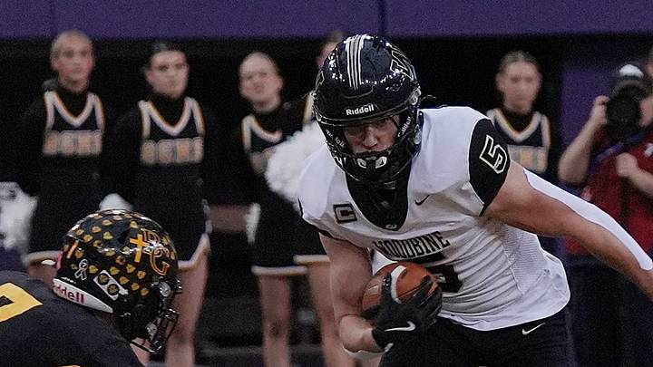 Woodbine wide receiver Landon Blum (5) runs with the ball after making a catch around Bishop Garrigan quarterback/defensive back Tate Foertsch (7) during the first quarter in the 8-players state football championship on Nov. 20, 2025, at UNI Dome in Cedar Falls, Iowa. Woodbine wide receiver Landon Blum (5) runs with the ball after making a catch around Bishop Garrigan quarterback/defensive back Tate Foertsch (7) during the first quarter in the 8-players state football championship on Nov. 20, 2025, at UNI Dome in Cedar Falls, Iowa.