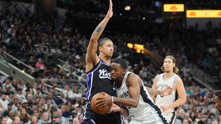Nov 16, 2025; San Antonio, Texas, USA; San Antonio Spurs guard De'Aaron Fox (4) drives in against Sacramento Kings guard Nique Clifford (5) in the first half at Frost Bank Center. Mandatory Credit: Daniel Dunn-Imagn Images
