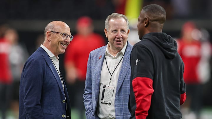 Tampa Bay Buccaneers owner Joel Glazer and owner Bryan Glazer talk to Atlanta Falcons head coach Raheem Morris.