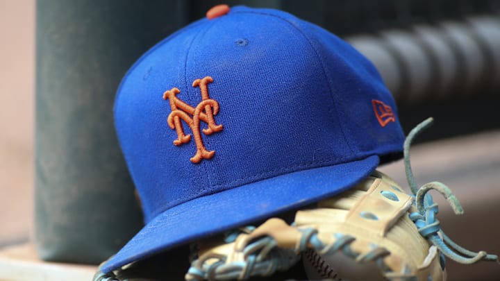 Jul 13, 2022; Atlanta, Georgia, USA; A detailed view of a New York Mets hat and glove in the dugout against the Atlanta Braves in the eighth inning at Truist Park.