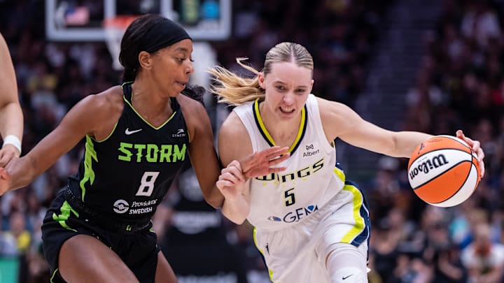 Jul 22, 2025; Seattle, Washington, USA;  Dallas Wings guard Paige Bueckers (5) dribbles the ball against Seattle Storm guard Lexie Brown (8) during the second half at Climate Pledge Arena. Mandatory Credit: Stephen Brashear-Imagn Images