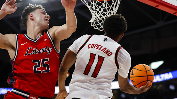 Dec 6, 2025; Raleigh, North Carolina, USA; NC State Wolfpack guard Quadir Copeland (11) goes for a dunk guarded by Liberty Flames forward Zach Cleveland (25) during the first half of the game at Lenovo Center. Mandatory Credit: Jaylynn Nash-Imagn Images Dec 6, 2025; Raleigh, North Carolina, USA; NC State Wolfpack guard Quadir Copeland (11) goes for a dunk guarded by Liberty Flames forward Zach Cleveland (25) during the first half of the game at Lenovo Center. Mandatory Credit: Jaylynn Nash-Imagn Images
