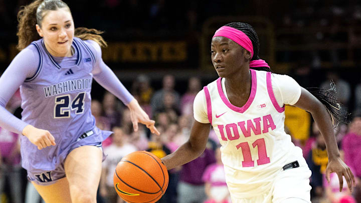 Iowa guard Chit-Chat Wright (11) dribbles down court against Washington guard Elle Ladine (24) Feb. 11, 2026 at Carver-Hawkeye Arena in Iowa City, Iowa.