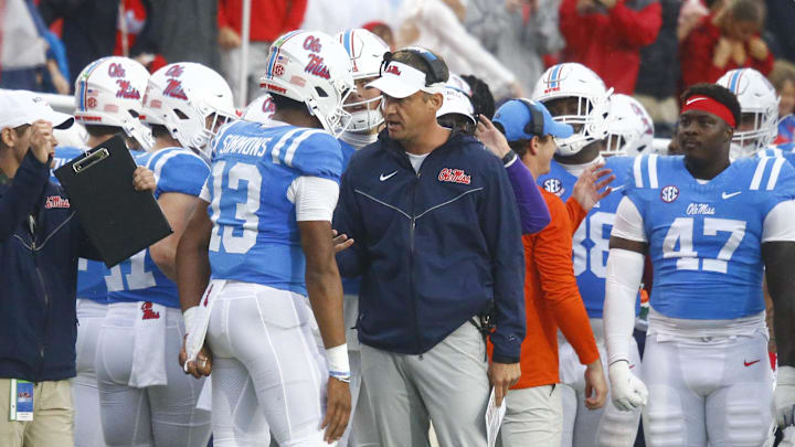 Nov 9, 2024; Oxford, Mississippi, USA; Mississippi Rebels head coach Lane Kiffin talks with quarterback Austin Simmons (13) after a touchdown during the first half against the Georgia Bulldogs at Vaught-Hemingway Stadium. Mandatory Credit: Petre Thomas-Imagn Images Nov 9, 2024; Oxford, Mississippi, USA; Mississippi Rebels head coach Lane Kiffin talks with quarterback Austin Simmons (13) after a touchdown during the first half against the Georgia Bulldogs at Vaught-Hemingway Stadium. Mandatory Credit: Petre Thomas-Imagn Images
