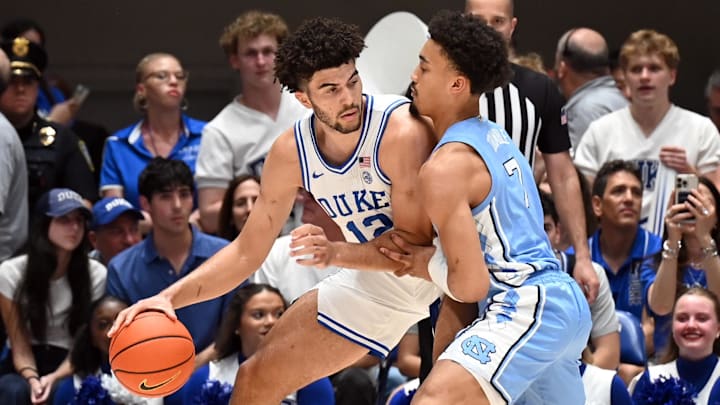 Mar 7, 2026; Durham, North Carolina, USA; Duke Blue Devils forward Cameron Boozer (12) controls the ball in front of North Carolina Tar Heels guard Seth Trimble (7) during the first half at Cameron Indoor Stadium. Mandatory Credit: Rob Kinnan-Imagn Images