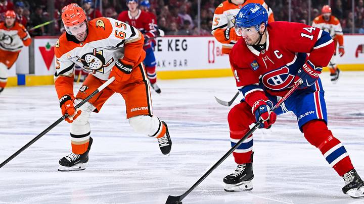 Mar 15, 2026; Montreal, Quebec, CAN; Montreal Canadiens center Nick Suzuki (14) plays the puck against Anaheim Ducks defenseman Jacob Trouba (65) during the third period at Bell Centre. Mandatory Credit: David Kirouac-Imagn Images