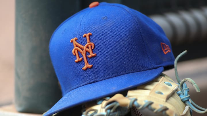 Jul 13, 2022; Atlanta, Georgia, USA; A detailed view of a New York Mets hat and glove in the dugout against the Atlanta Braves in the eighth inning at Truist Park. 