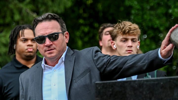Michigan State's head coach Jonathan Smith touches the foot of the Sparty statue before the game against Florida Atlantic on Friday, Aug. 30, 2024, outside Spartan Stadium in East Lansing.