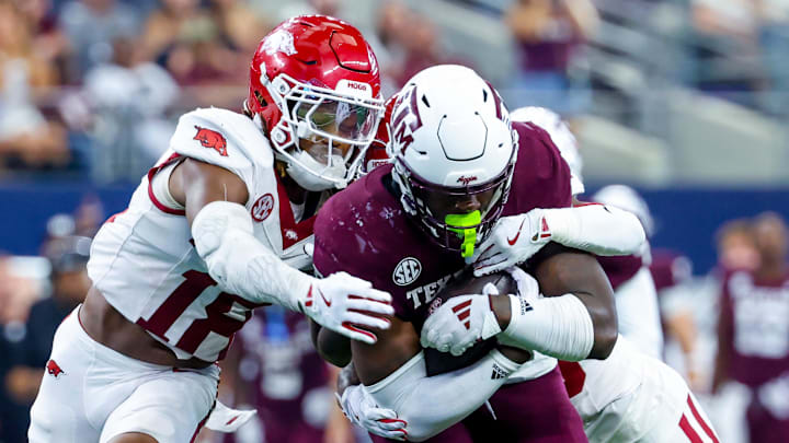 Texas A&M Aggies running back Le'Veon Moss (8) is drug down by Arkansas Razorbacks defensive back TJ Metcalf (18) defends during the second half at AT&T Stadium. Texas A&M Aggies running back Le'Veon Moss (8) is drug down by Arkansas Razorbacks defensive back TJ Metcalf (18) defends during the second half at AT&T Stadium.