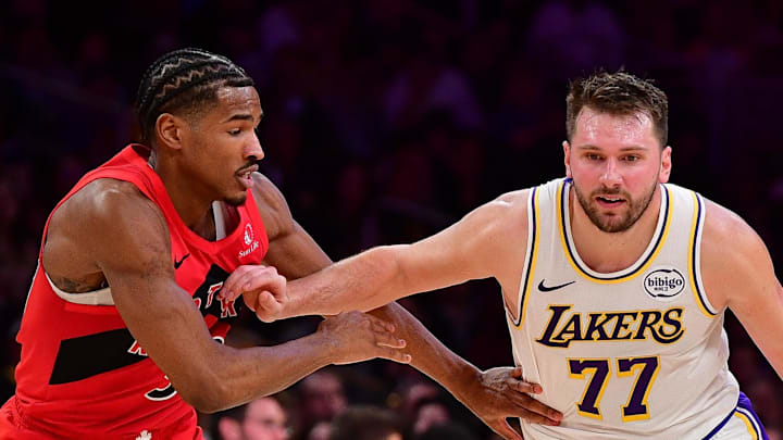 Los Angeles Lakers guard Luka Doncic moves the ball against Toronto Raptors guard Ochai Agbaji.