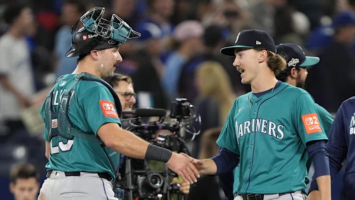 Mariners catcher Cal Raleigh, left, and pitcher Bryce Miller celebrate winning Game 1.