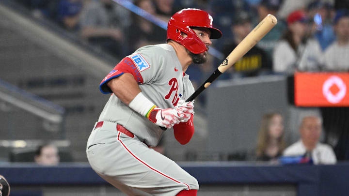 Jun 4, 2025; Toronto, Ontario, CAN;  Philadelphia Phillies designated hitter Kyle Schwarber (12) hits a single against the Toronto Blue Jays in the fourth inning at Rogers Centre. 