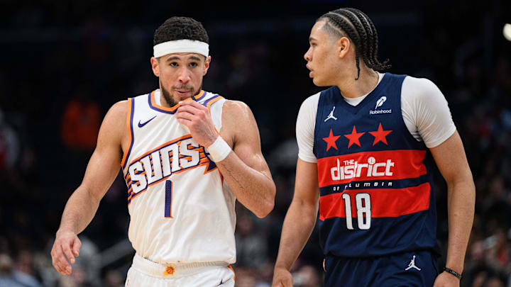 Jan 16, 2025; Washington, District of Columbia, USA; Phoenix Suns guard Devin Booker (1) looks  on as Washington Wizards forward Kyshawn George (18) defends during the third quarter at Capital One Arena. Mandatory Credit: Reggie Hildred-Imagn Images