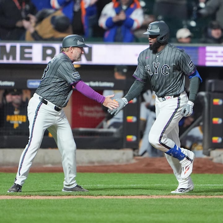 New York Mets third base coach Tim Leiper (63) congratulates Luis Robert Jr. (88)