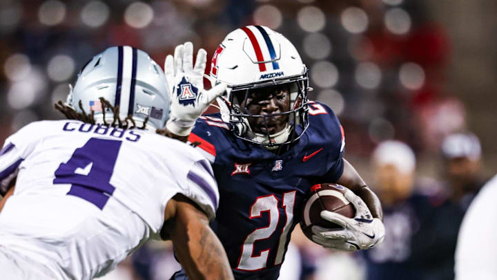 Sep 12, 2025; Tucson, Arizona, USA; Arizona Wildcats running back Ismail Mahdi (21) runs the ball while Kansas State Wildcats safety Daniel Cobbs (4) defends during the fourth quarter at Arizona Stadium. Mandatory Credit: Aryanna Frank-Imagn Images Sep 12, 2025; Tucson, Arizona, USA; Arizona Wildcats running back Ismail Mahdi (21) runs the ball while Kansas State Wildcats safety Daniel Cobbs (4) defends during the fourth quarter at Arizona Stadium. Mandatory Credit: Aryanna Frank-Imagn Images