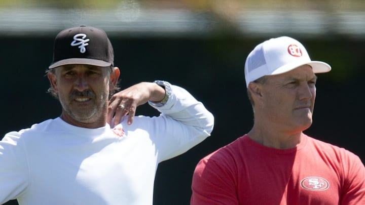 Jun 10, 2025; Santa Clara, CA, USA; San Francisco 49ers head coach Kyle Shanahan (left) and general manager John Lynch watch their team work out during an OTA at Levi's Stadium. Mandatory Credit: D. Ross Cameron-Imagn Images