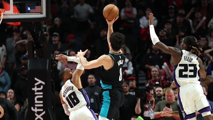 Dec 18, 2025; Portland, Oregon, USA;  Sacramento Kings guard Russell Westbrook (18) fouls Portland Trail Blazers forward Deni Avdija (8) in the closing seconds of overtime at Moda Center.