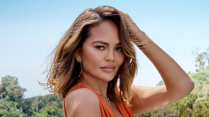 Chrissy Teigen was photographed by Yu Tsai in Los Angeles. Swimsuit by Yves Saint Laurent. Earrings by Jacquie Aiche. Necklace by Jacquie Aiche.