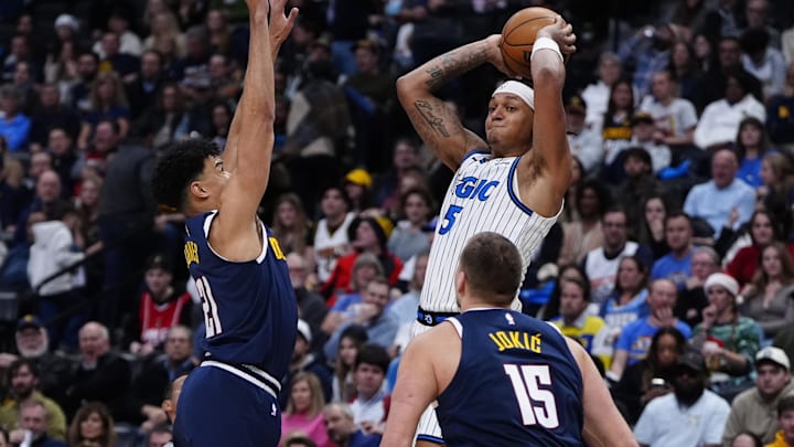 Dec 18, 2025; Denver, Colorado, USA; Denver Nuggets forward Spencer Jones (21) and center Nikola Jokic (15) defend on Orlando Magic forward Paolo Banchero (5) during the second half at Ball Arena. Mandatory Credit: Ron Chenoy-Imagn Images