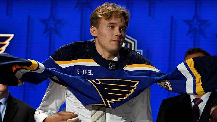 Jun 28, 2023; Nashville, Tennessee, USA; St. Louis Blues draft pick Theo Lindstein puts on his sweater after being selected with the twenty ninth pick in round one of the 2023 NHL Draft at Bridgestone Arena. Mandatory Credit: Christopher Hanewinckel-Imagn Images