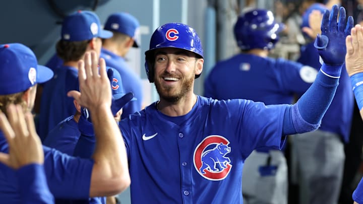 Chicago Cubs outfielder Cody Bellinger celebrates with his teammates in the dugout after hitting a home run.