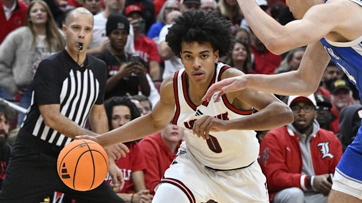 Nov 11, 2025; Louisville, Kentucky, USA;  Louisville Cardinals guard Mikel Brown Jr. (0) dribbles against Kentucky Wildcats forward Andrija Jelavic (4) during the second half at KFC Yum! Center. Louisville defeated Kentucky 96-88. Mandatory Credit: Jamie Rhodes-Imagn Images
