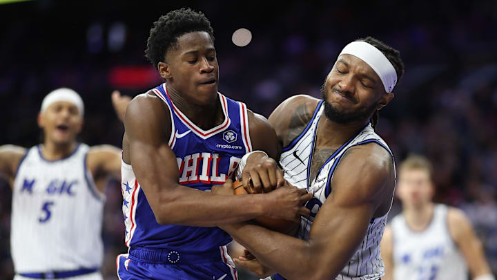 Oct 27, 2025; Philadelphia, Pennsylvania, USA; Philadelphia 76ers guard VJ Edgecombe (77) and Orlando Magic center Wendell Carter Jr. (34) wrestle for ball control during the fourth quarter at Xfinity Mobile Arena. Mandatory Credit: Bill Streicher-Imagn Images