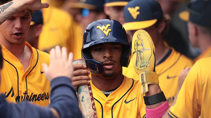 West Virginia Mountaineers junior Armani Guzman (5) is celebrated after scoring a run against Kansas Jayhawks during the game inside Hoglund Ballpark on May 10, 2026.