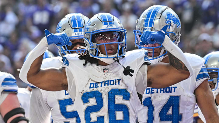Oct 20, 2024; Minneapolis, Minnesota, USA; Detroit Lions running back Jahmyr Gibbs (26) reacts with wide receiver Amon-Ra St. Brown (14) and offensive tackle Penei Sewell (rear) after running for an 8 yard touchdown during the second quarter against the Minnesota Vikings at U.S. Bank Stadium. 