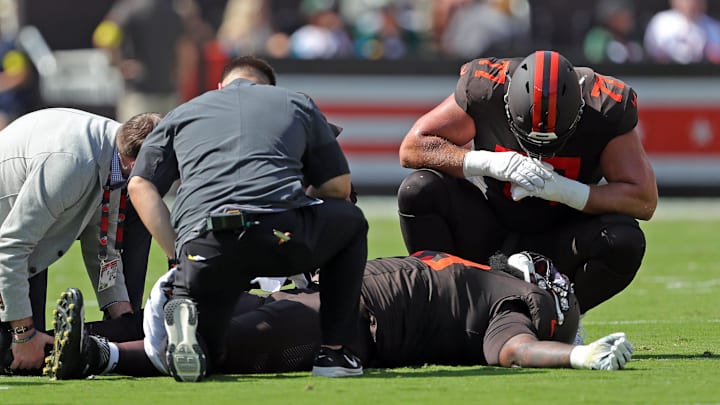 Cleveland Browns guard Wyatt Teller (77) checks on offensive tackle Dawand Jones (79) after sustaining an injury during the first half of an NFL football game against the Green Bay Packers at Huntington Bank Field, Sept. 21, 2025, in Cleveland, Ohio.