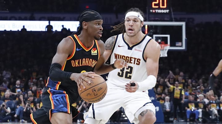 May 5, 2025; Oklahoma City, Oklahoma, USA; Oklahoma City Thunder guard Shai Gilgeous-Alexander (2) drives around Denver Nuggets forward Aaron Gordon (32) during the second half during game one of the second round for the 2025 NBA Playoffs at Paycom Center. Mandatory Credit: Alonzo Adams-Imagn Images
