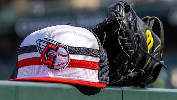 Jul 8, 2024; Detroit, Michigan, USA; A Cleveland Guardians baseball cap and glove sit on the dugout rail before the game against the Detroit Tigers at Comerica Park. Mandatory Credit: David Reginek-Imagn Images